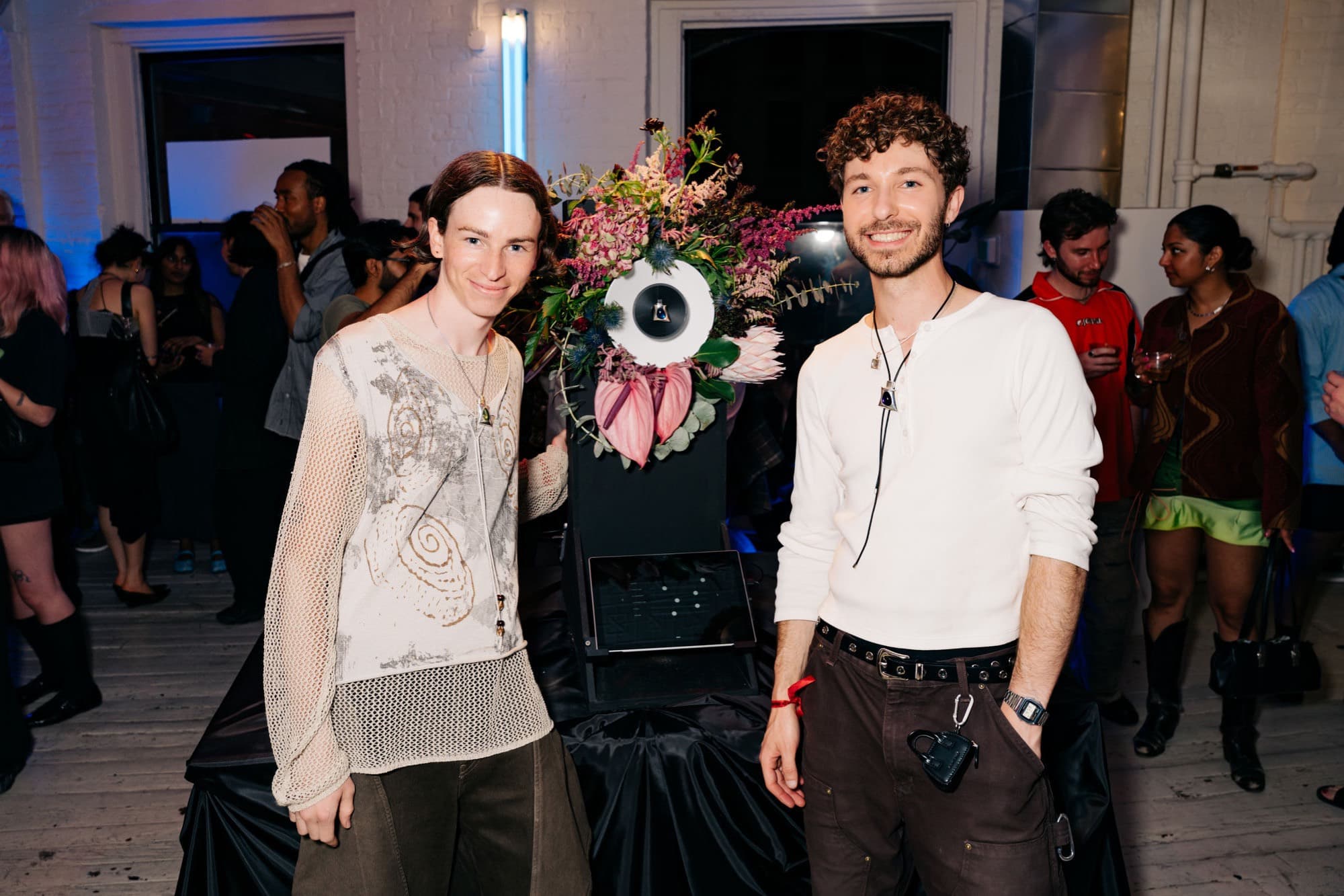 Noware founders Harry Isaac and Sebastian Bidegain at the PUFF launch party, with PUFF mounted in a floral arrangement between them.
